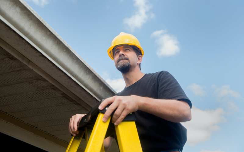 Gutter contractor Inspecting residential gutter
